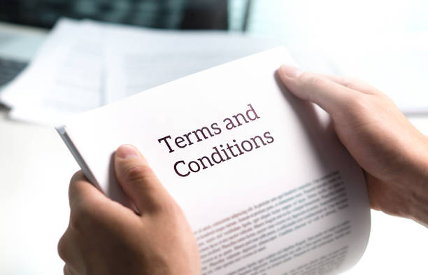 a guy reading a book which says "Terms and conditions"